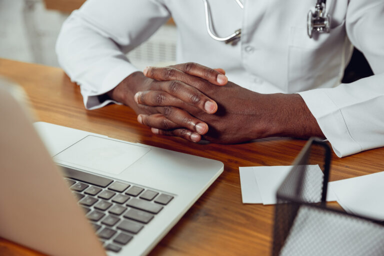 African-american doctor consulting for patient, working in cabinet, close up